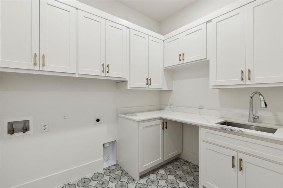 Laundry area featuring hookup for a washing machine, hookup for an electric dryer, light tile designer tile floors, cabinets, and sink