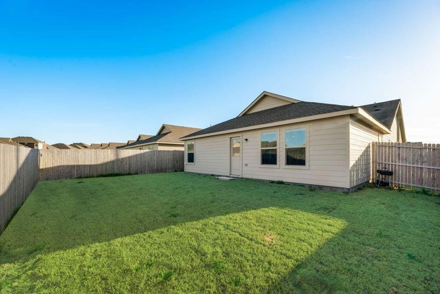 Rear view of house with a lawn