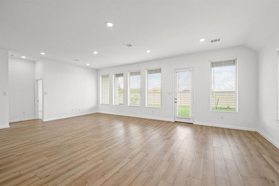 Large oversize living room with natural lighting overseeing the covered patio. Wood blinds on the windows