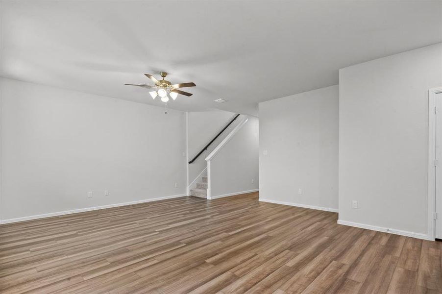 Empty room with ceiling fan and light hardwood / wood-style flooring