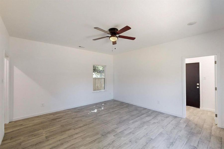 Primary bedroom featuring light hardwood / wood-style flooring and ceiling fan