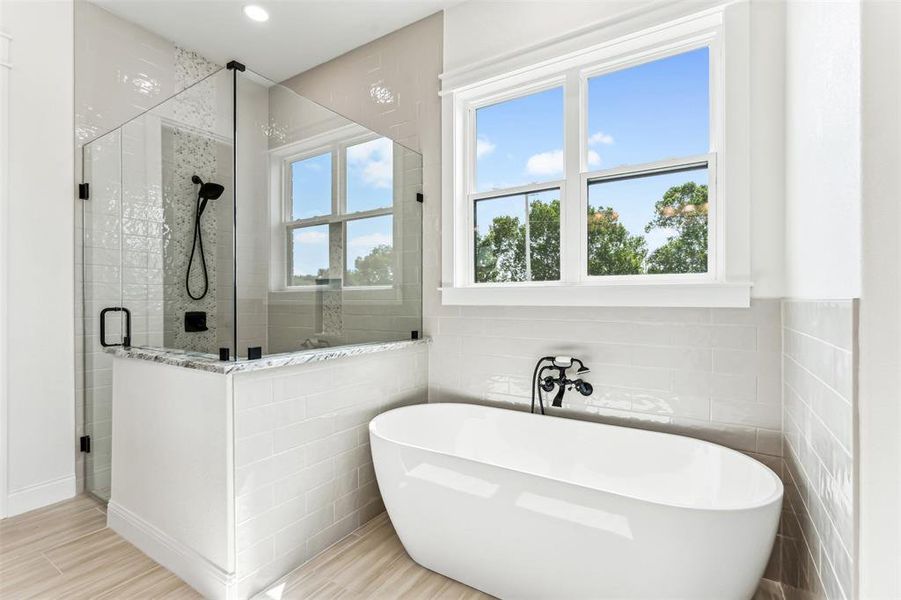 Bathroom featuring tile patterned floors, separate shower and tub, and tile walls