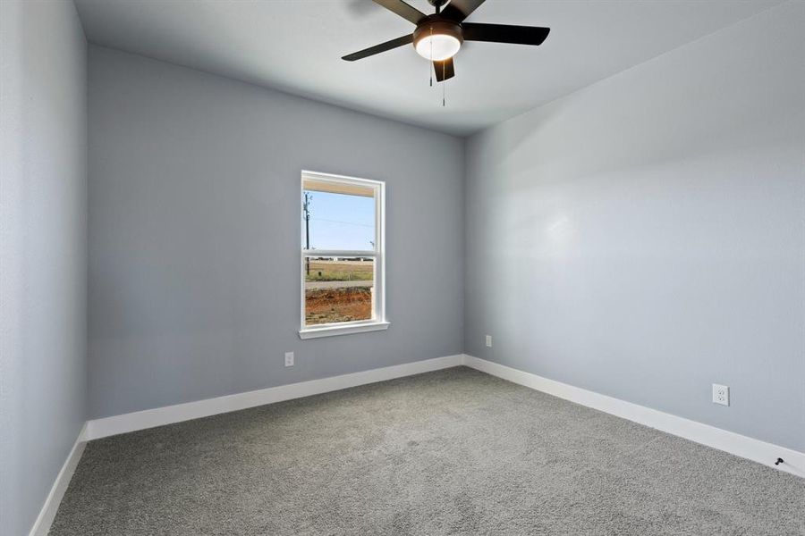 Carpeted spare room featuring ceiling fan