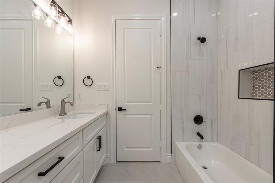 Double sinks in the secondary bathroom with shower and tub tiled combo