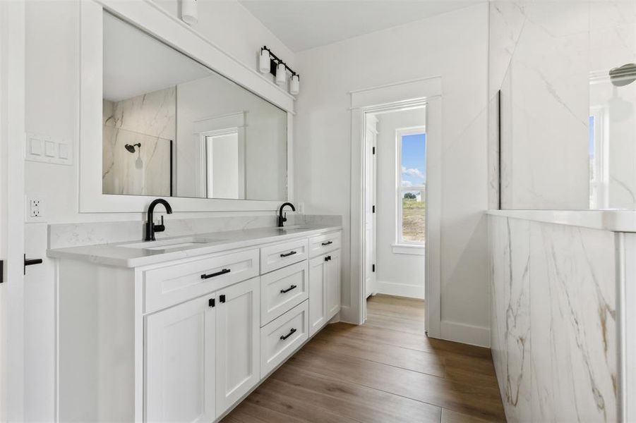 Bathroom featuring tiled shower, vanity, and hardwood / wood-style flooring