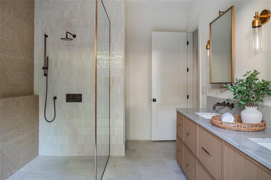 Bathroom featuring tile flooring, walk in shower, and double vanity
