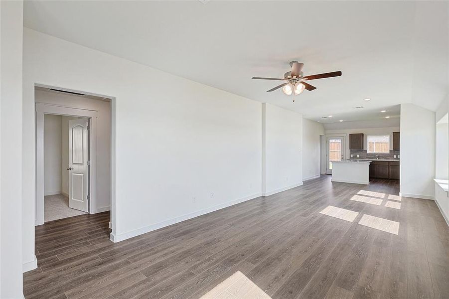 Unfurnished living room featuring dark hardwood / wood-style floors and ceiling fan