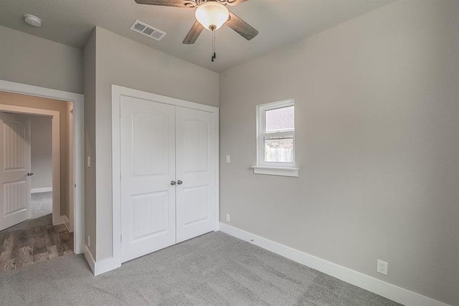 Unfurnished bedroom with ceiling fan, a closet, and hardwood / wood-style flooring