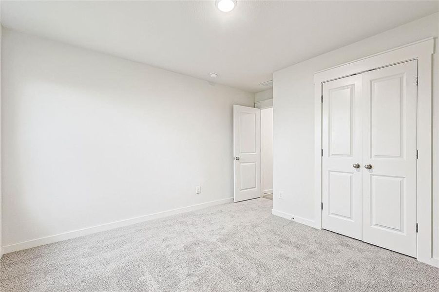 Unfurnished bedroom with a closet and light colored carpet