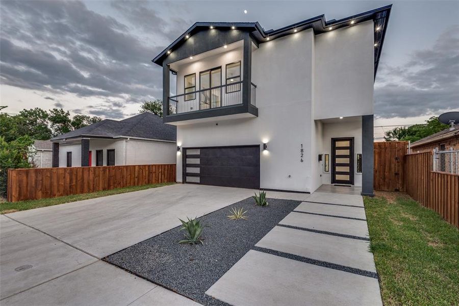 Modern two story home with garage and balcony.