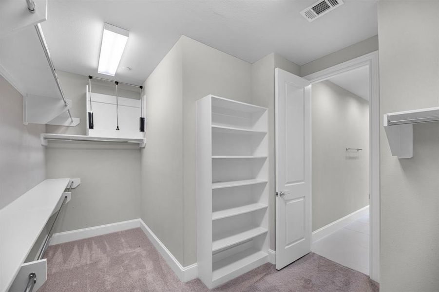 The primary retreat offers a generously sized walk-in closet, designed for optimal organization and convenience. It features 2 levels of shelves along with hanging rods, allowing for easy access & arrangement of your wardrobe. Additionally, a spacious built-in shelf provides extra room for storage.