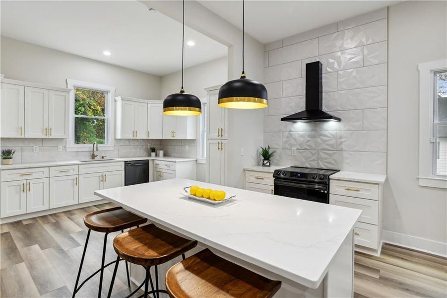 Kitchen featuring wall chimney exhaust hood, a center island, electric stove, and backsplash