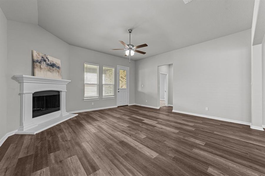 Unfurnished living room featuring lofted ceiling, ceiling fan, and dark hardwood / wood-style flooring