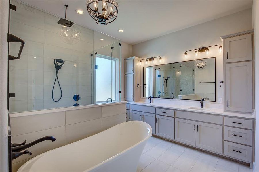 Bathroom with independent shower and bath, double sink, tile floors, vanity with extensive cabinet space, and a chandelier