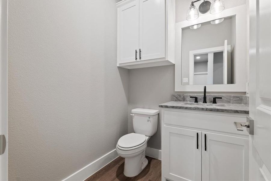 Bathroom featuring wood-type flooring, vanity, and toilet