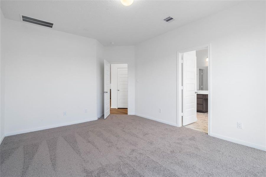 Another view of this primary suite looking into the primary bathroom.