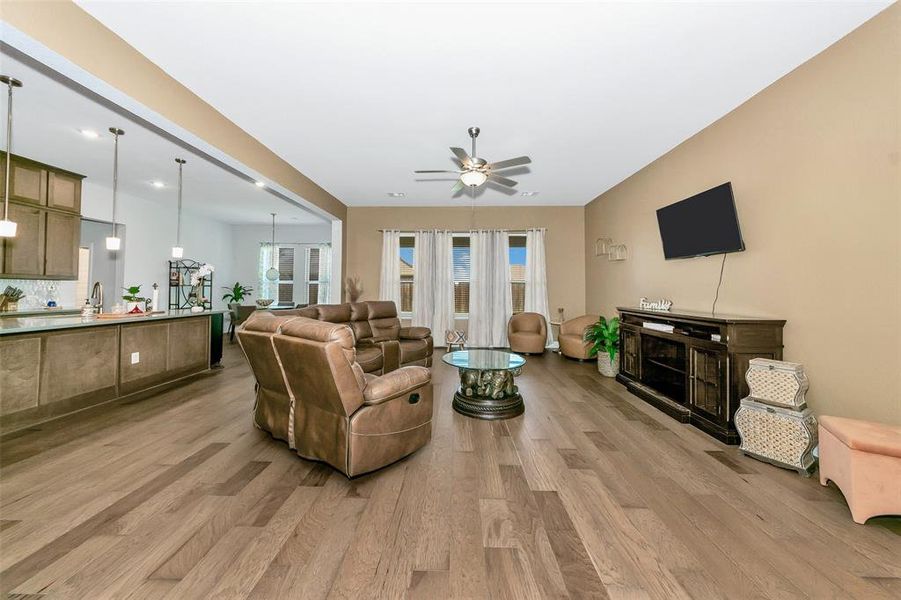 Living room featuring light hardwood / wood-style floors and ceiling fan with notable chandelier