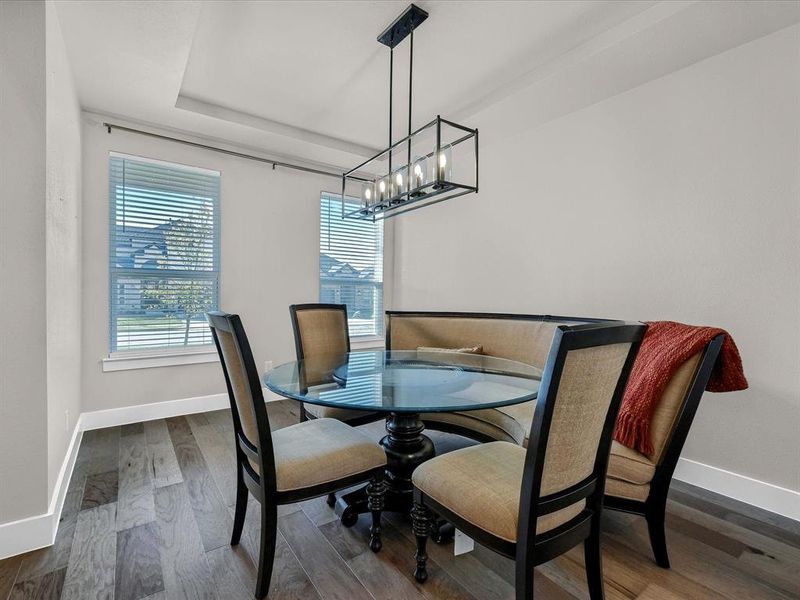 Dining room with dark wood-type flooring and a notable chandelier