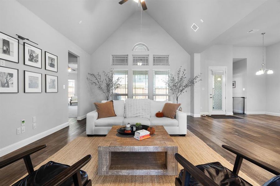 Living room has view of backyard through multiple decorative windows.