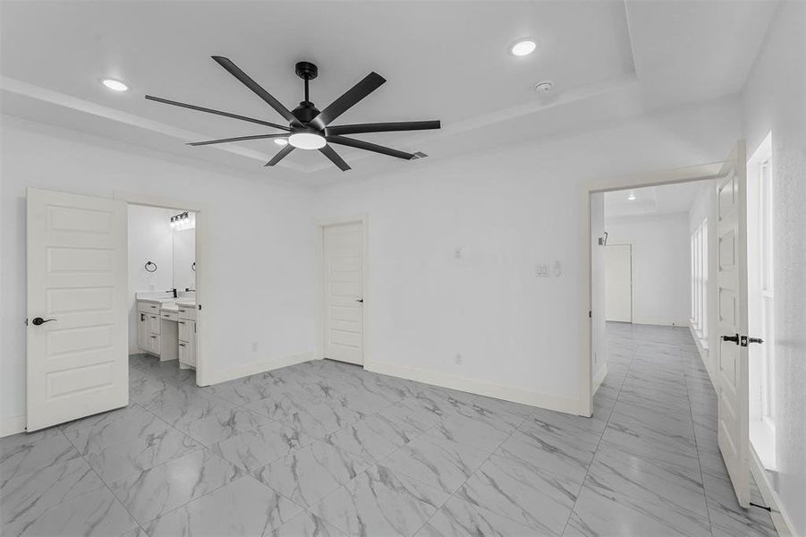 Unfurnished bedroom with ceiling fan and ensuite bathroom