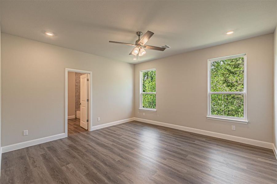 Spare room with dark hardwood / wood-style floors and a healthy amount of sunlight