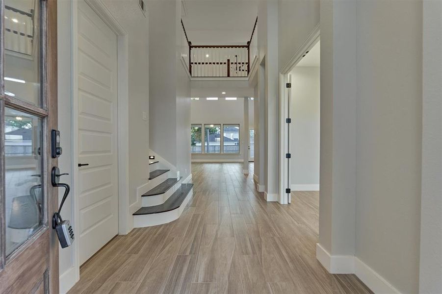 The interior of the home is filled with calming light colors and a subtle hint of dark stained wood. A private office is to the right of the entry and the utility room with access to the garage is to the left.