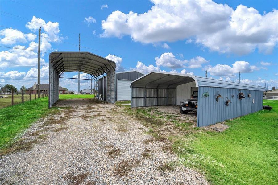 View of outdoor structure with a carport and a yard