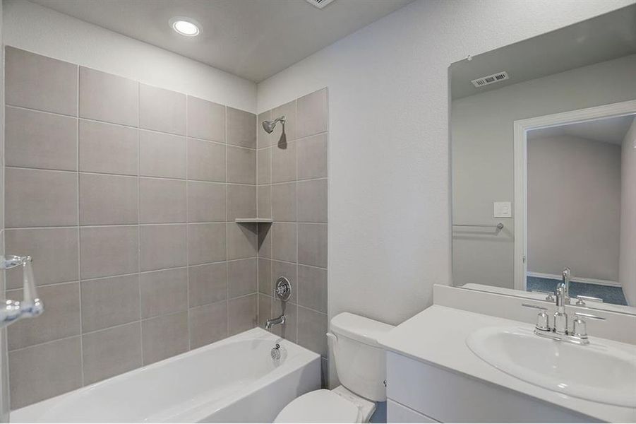 Full bathroom featuring vanity, toilet, and tiled shower / bath