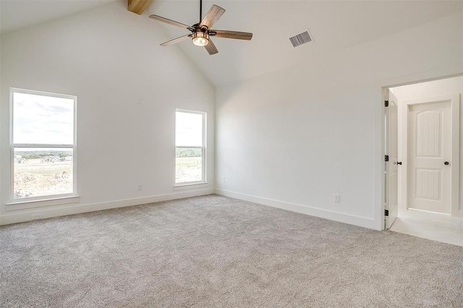 Spare room featuring ceiling fan, beamed ceiling, light carpet, and high vaulted ceiling