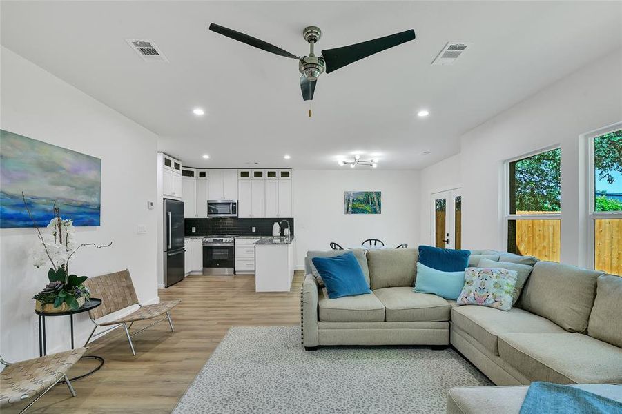 Living room with light wood-type flooring and ceiling fan