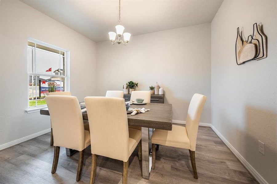 Create lasting memories with your family and friends at the dining table! This expansive dining room showcases sophisticated flooring, custom paint, and large windows for natural light.  Sample photo of completed home. Actual color and selections may vary.