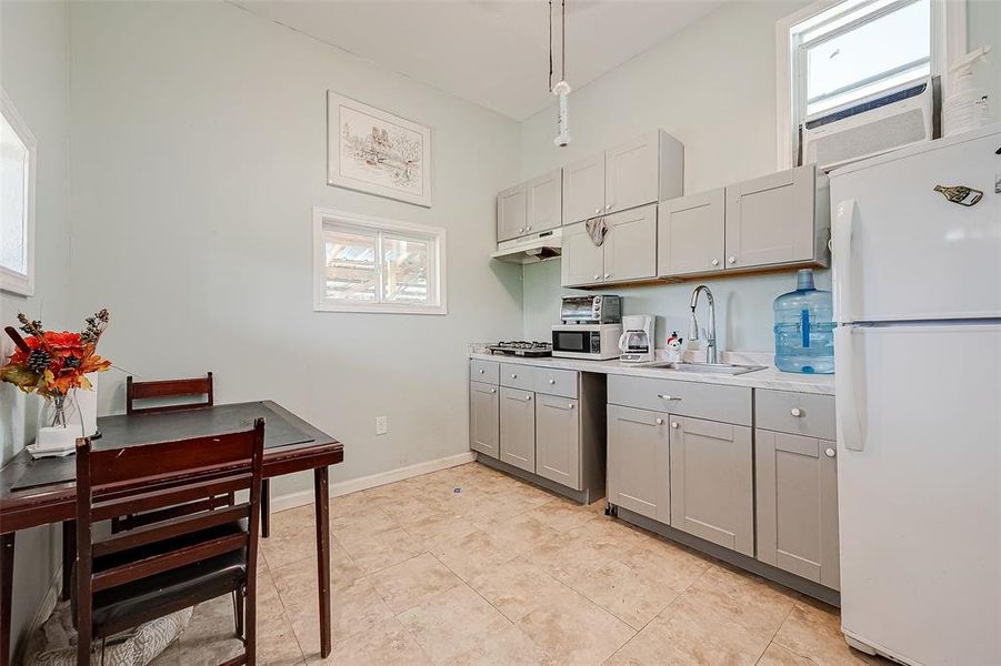 The dining area and kitchen are seamlessly integrated, creating a cohesive and functional space for cooking, dining, and entertaining.