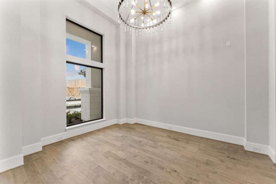 -- Representational Photo -- Front Formal Dining Room with modern window design to give a view out as well as let light in. The charming and chic chandelier creates an inviting space to entertain guests in this grand space.