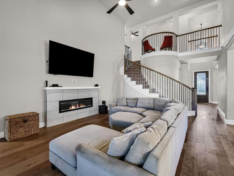 Living room with hardwood / wood-style floors, a fireplace, and high vaulted ceiling