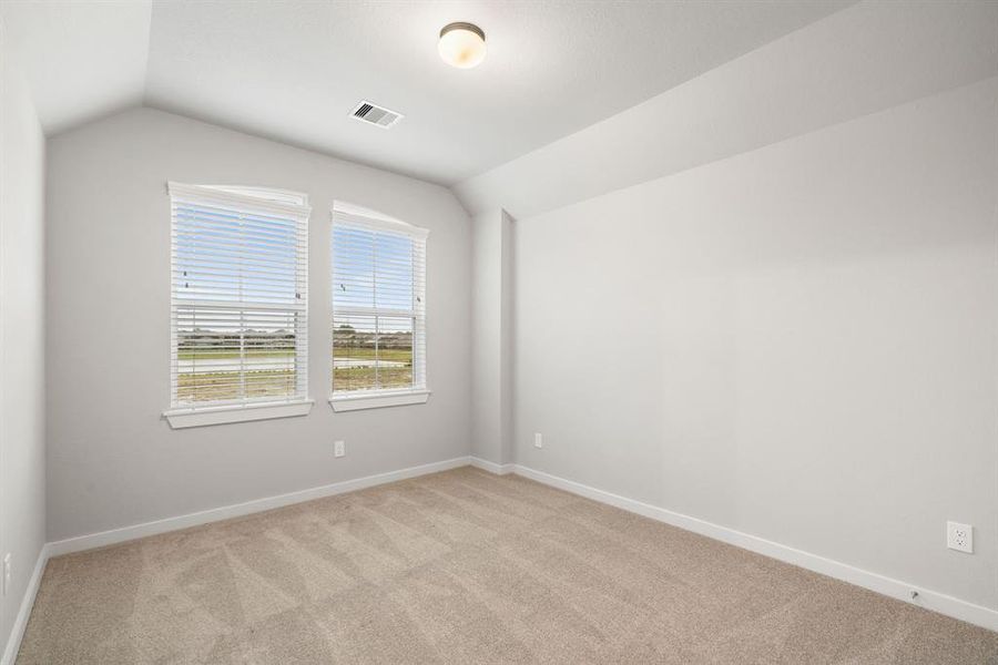Generously sized secondary bedrooms featuring spacious closets, soft and inviting carpeting underfoot, large windows allowing plenty of natural light. Sample photo of completed home with similar floor plan. As-built interior colors and selections may vary.