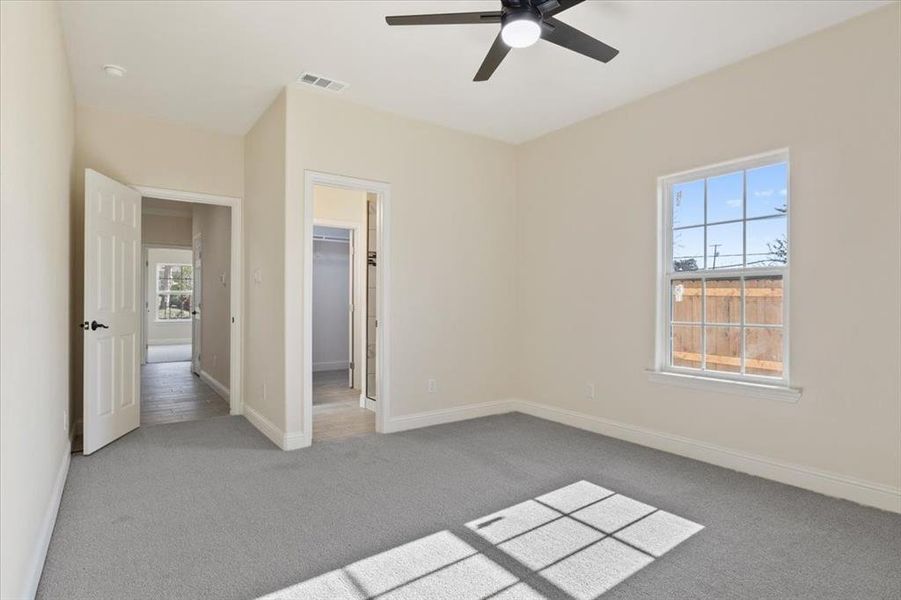 Unfurnished bedroom with ceiling fan, carpet, a closet, and a spacious closet