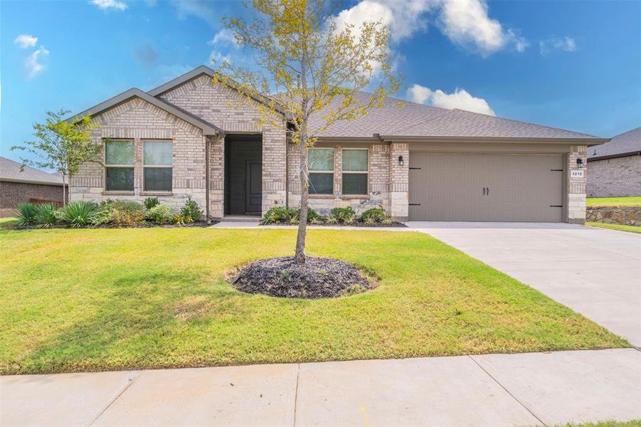 View of front of home featuring a garage and a front lawn