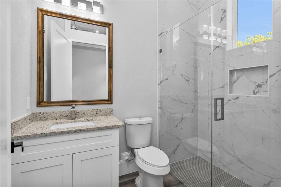 Bathroom #5. All Secondary Bathrooms offer walk-in showers with frameless glass and large inset storage and the same clean modern finishings used throughout the home, along with Delta sinks, faucets and shower shower finishings.
