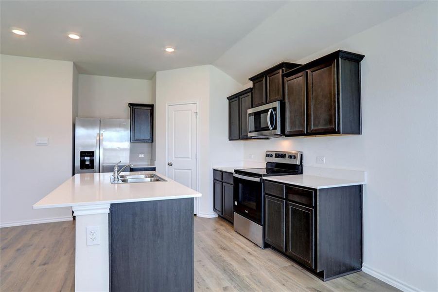 Kitchen featuring an island with sink, light hardwood / wood-style floors, sink, and stainless steel appliances