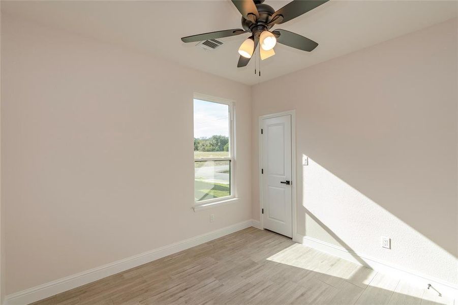 Unfurnished room featuring light hardwood / wood-style flooring and ceiling fan