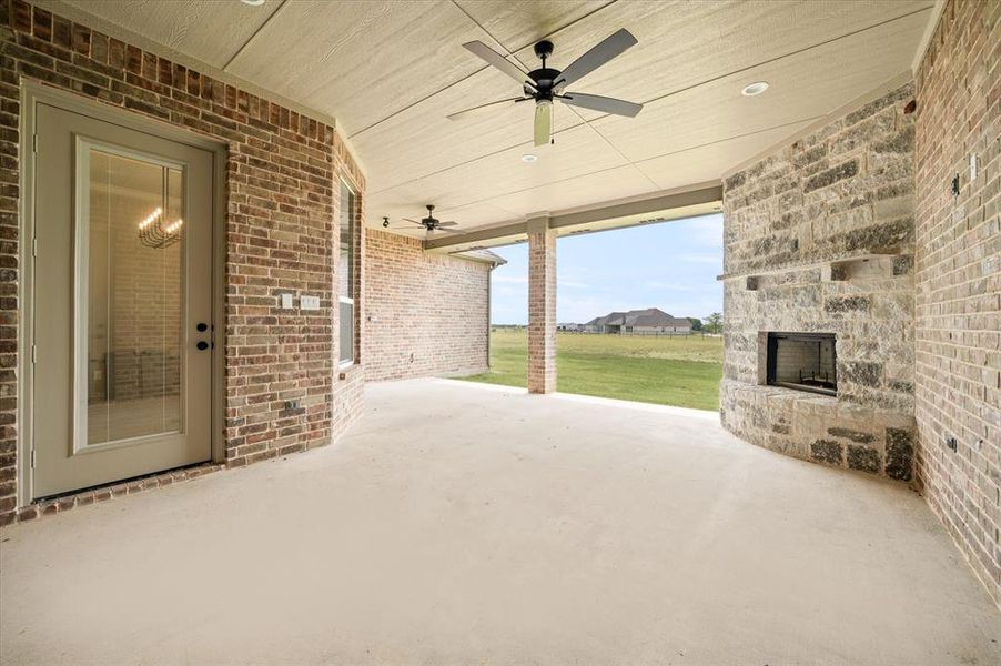 View of patio featuring a large fireplace and ceiling fan