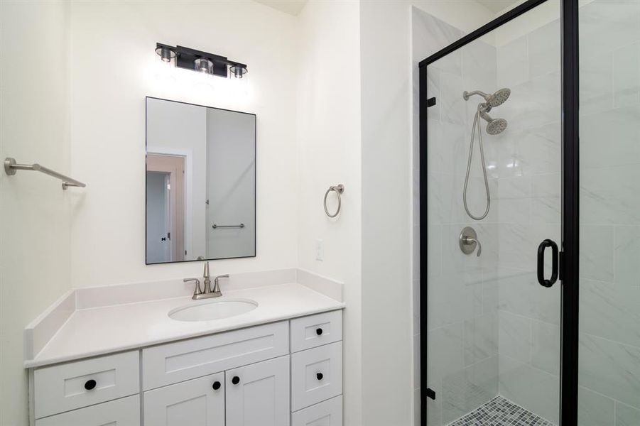 Bathroom featuring an enclosed shower and vanity