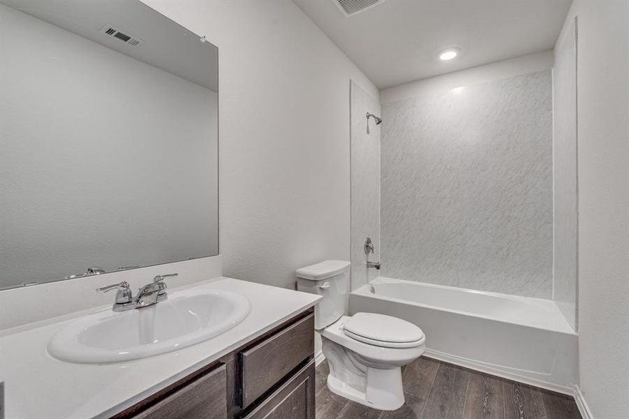 Full bathroom with vanity, toilet, shower / bathing tub combination, and hardwood / wood-style flooring