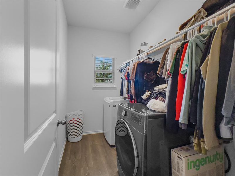 Washroom featuring hardwood / wood-style flooring and washer and dryer