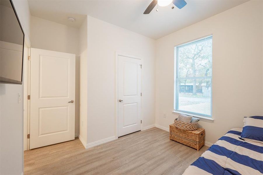 Bedroom featuring multiple windows, light hardwood / wood-style floors, and ceiling fan