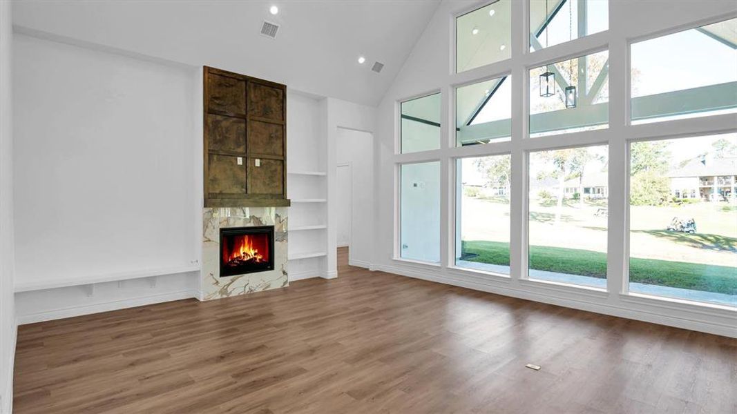 The living area with gas log, tile surround fire place and warm stained wood accent wall, leads to the office and primary suite. Convenient floor plug in living room for accent lamps.