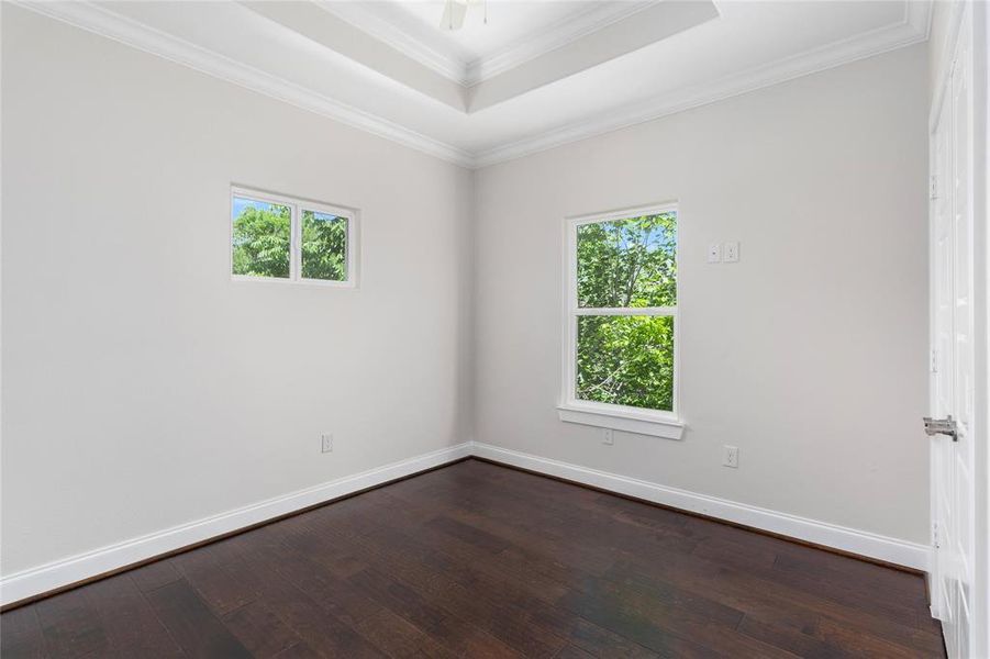 Upstairs bedroom with crown molding and baseboard molding.