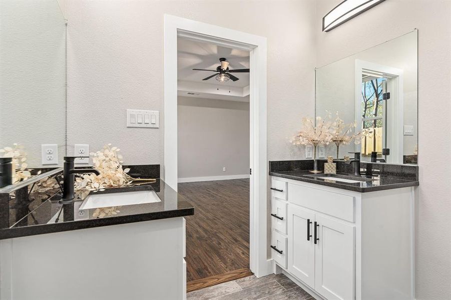 Bathroom with wood-type flooring, ceiling fan, and vanity