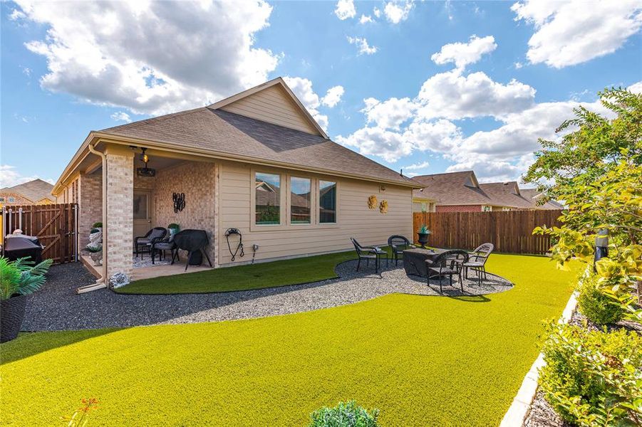 Rear view of house featuring a lawn and a patio