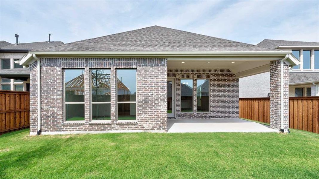 Rear view of property with a yard and a patio area